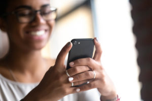 young woman smiling using smart phone