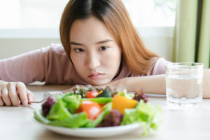 girl looks at plate of food