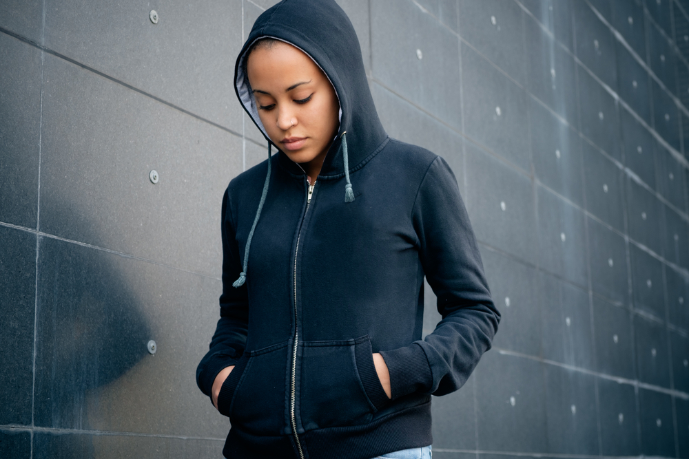 sad or depressed teenage girl in hoodie